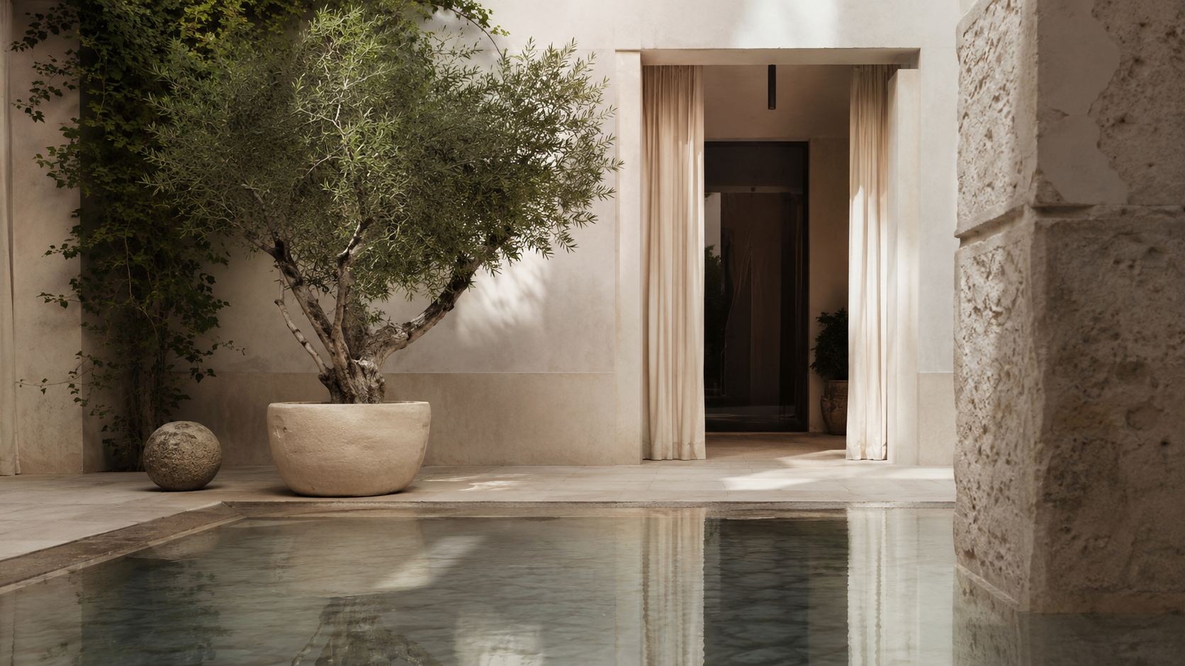 Quiet hotel courtyard with pool and olive tree.